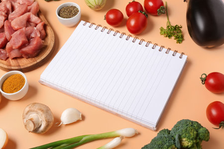 Composition with blank recipe book, raw meat, vegetables and spices on color backgroundの写真素材