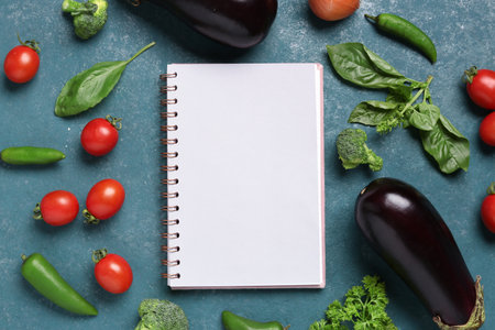Composition with blank recipe book, fresh vegetables and herbs on color backgroundの写真素材