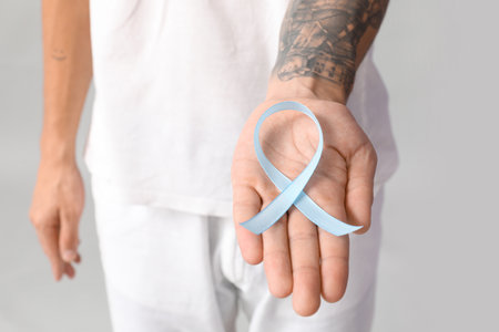 Handsome man with blue ribbon on gray background. Prostate cancer conceptの写真素材