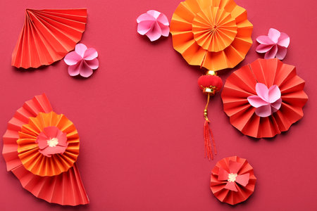 Fans with paper flowers and oriental symbol on red background. New Year celebrationの写真素材