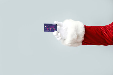 Santa Claus with credit card on gray backgroundの写真素材