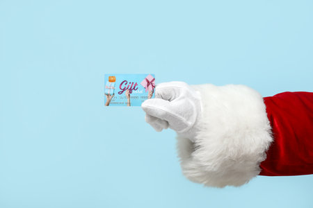 Santa Claus with gift card on blue backgroundの写真素材