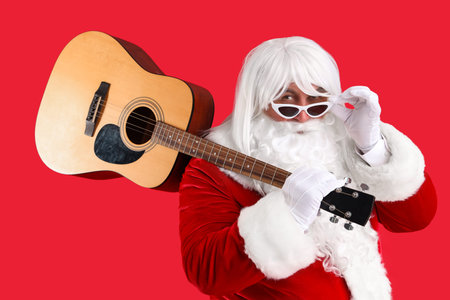 Cool Santa Claus with guitar on red backgroundの写真素材