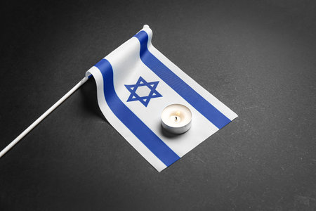 Flag of Israel with burning candle on dark backgroundの写真素材