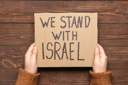 Female hands and text WE STAND WITH ISRAEL on wooden backgroundの写真素材