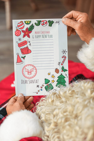 Santa Claus reading letter at home on Christmas Eve, closeup