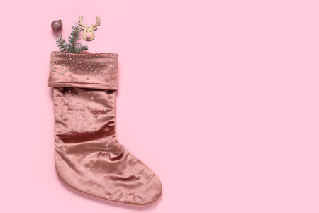 Christmas sock with fir branch and beautiful decorations on pink backgroundの写真素材