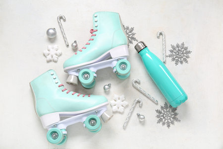 Composition with roller skates, sports bottle and Christmas decorations on white background