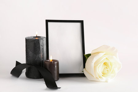 Black photo frame with candles and roses on white backgroundの写真素材