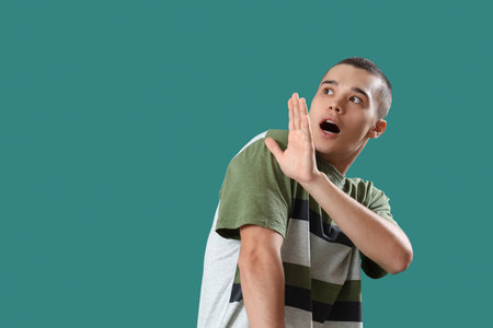 Afraid young man on green backgroundの写真素材