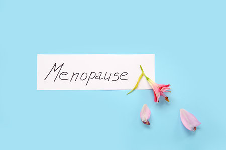 Word MENOPAUSE with flower on blue backgroundの写真素材