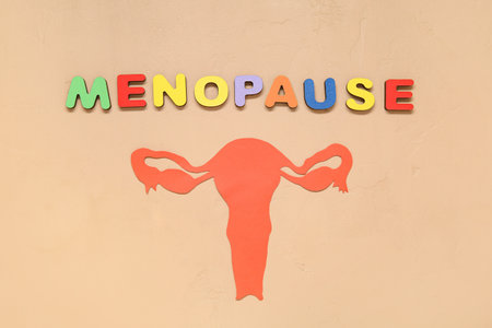 Word MENOPAUSE with paper uterus on beige backgroundの写真素材