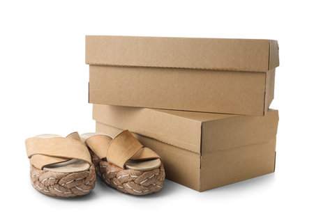 Stylish beige sandals and boxes on white backgroundの写真素材