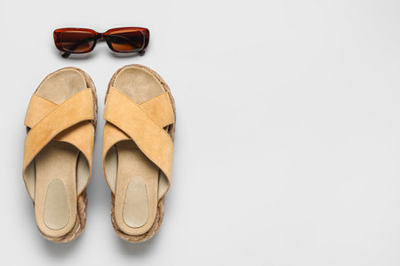 Stylish beige sandals and sunglasses on gray backgroundの写真素材