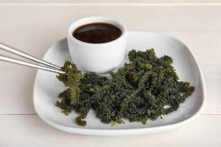 Plate with healthy seaweed and soy sauce on light wooden backgroundの写真素材