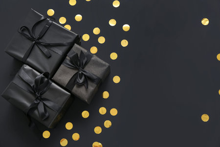 Gift boxes and confetti on dark background. Black Friday