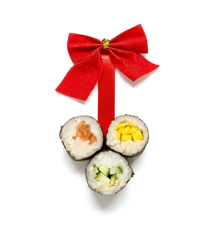 Composition with tasty sushi rolls and bow for Christmas party on white backgroundの写真素材