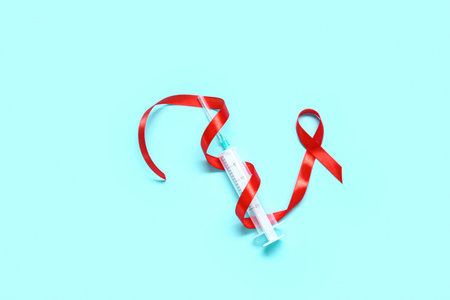 Red ribbon with syringe on blue background. AIDS Day concept