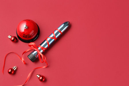 Vibrator with bow, ring for sex and Christmas balls on red backgroundの写真素材