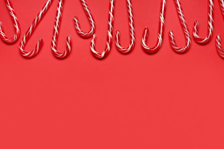 Many Christmas candy canes on red backgroundの写真素材