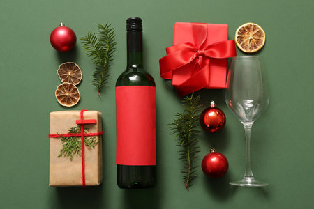 Bottle of wine with glass and Christmas gift boxes on green backgroundの写真素材