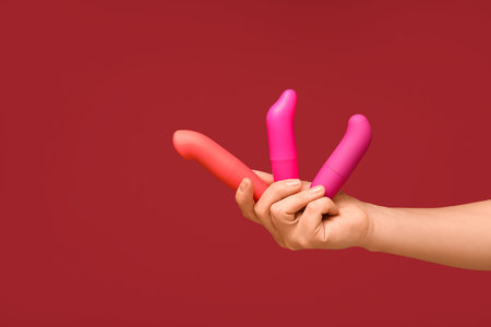 Woman with vibrators on red background