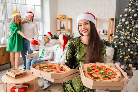 Young woman with pizza at Christmas partyの写真素材