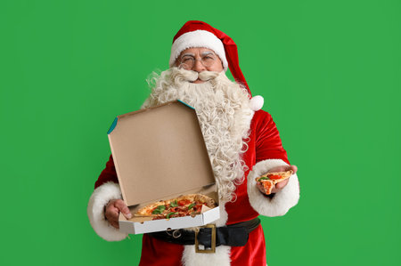 Santa Claus with box of tasty pizza on green backgroundの写真素材
