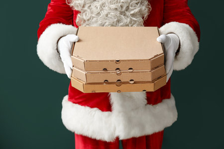 Santa Claus with boxes of tasty pizza on green backgroundの写真素材