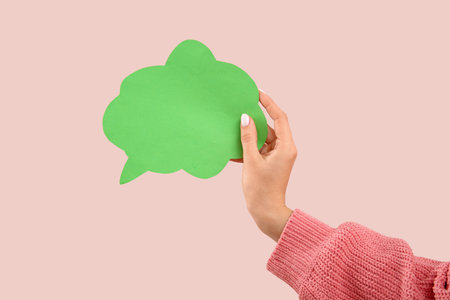 Female hand with blank speech bubble on pink backgroundの写真素材