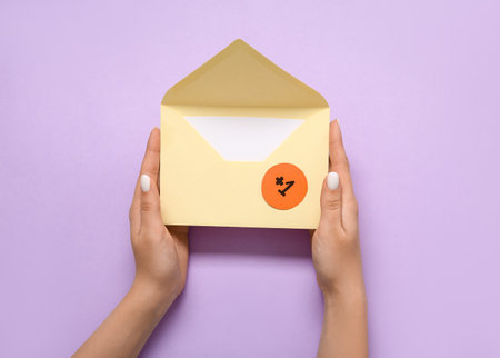 Female hands holding envelope with +1 icon on lilac background. New messageの写真素材