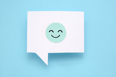 Speech bubble with happy face on blue backgroundの写真素材