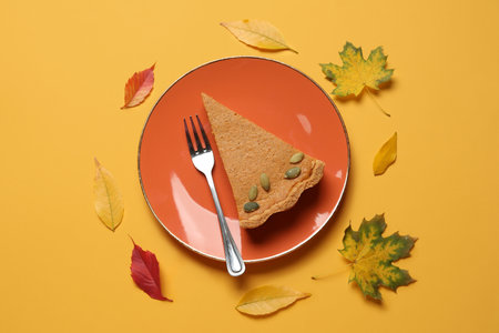Autumn composition with tasty pumpkin pie on yellow backgroundの写真素材