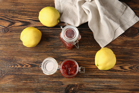 Jars of jam and quince fruits on wooden backgroundの写真素材