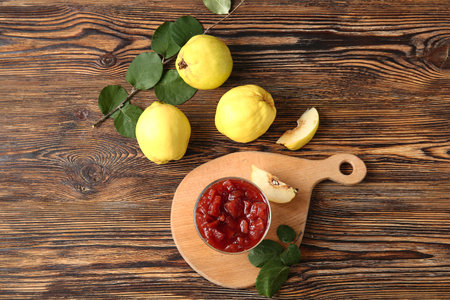 Bowl with jam and quince fruits on wooden backgroundの写真素材