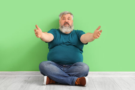 Mature man opening arms for hug near green wallの写真素材