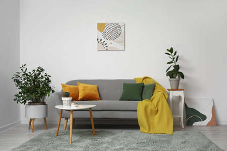 Interior of modern living room with gray sofa, cushions and houseplants