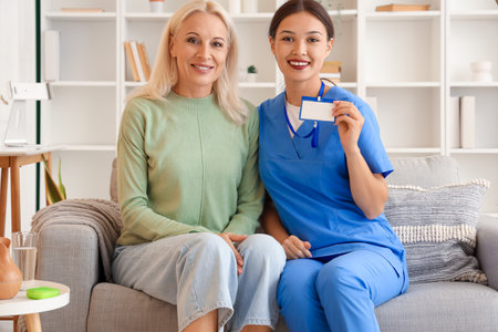 Mature woman with doctor at homeの写真素材