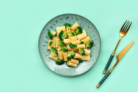 Plate of tasty pasta with broccoli on turquoise backgroundの写真素材