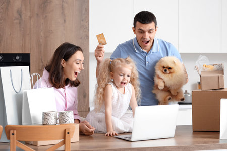 Happy family with cute dog shopping online in kitchenの写真素材