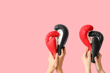 Female hands with boxing gloves on pink backgroundの写真素材
