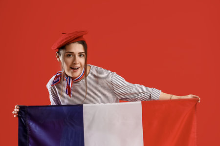 Young woman with flag of France on red backgroundの写真素材