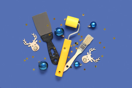 Composition with painter's tools and Christmas decorations on blue background