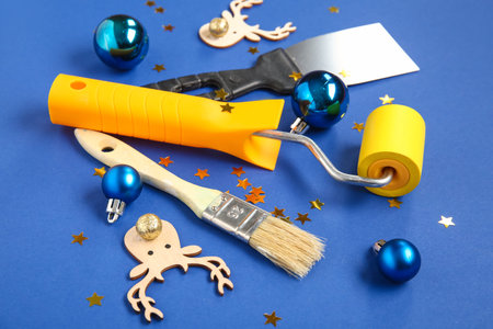 Composition with painter's tools and Christmas decorations on blue background