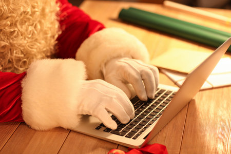 Santa Claus using laptop at tableの写真素材