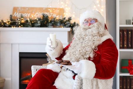 Santa Claus drinking milk with cookies at home on Christmas Eveの写真素材