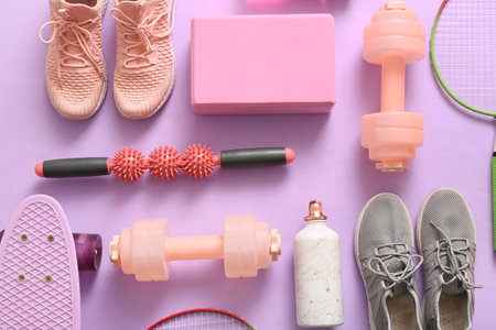 Different sports equipment and sneakers on lilac backgroundの写真素材