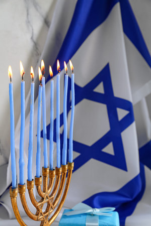 Menorah with burning candles, gift and flag of Israel, closeupの写真素材