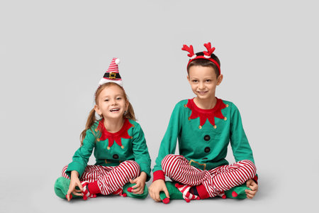 Cute little children dressed as elves on gray backgroundの写真素材