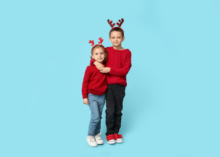 Cute little children in reindeer horns on blue backgroundの写真素材